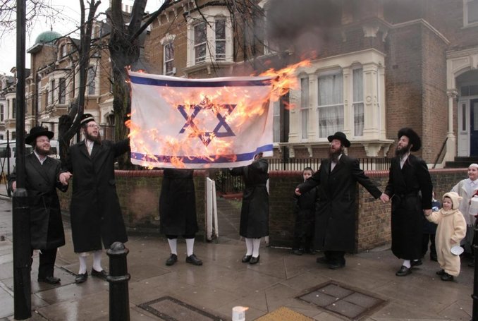 Des juifs antisionistes brûlent le drapeau israélien. (Photo via Twitter)