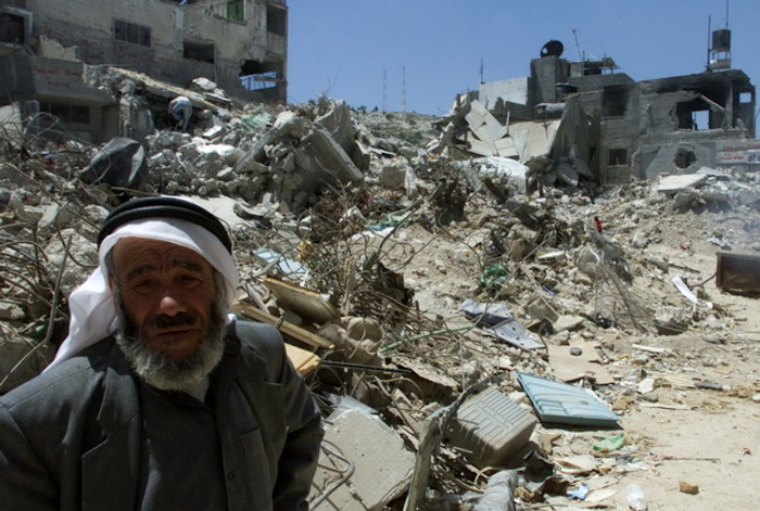 AN ELDERLY PALESTINIAN MAN STANDS NEXT TO HIS DESTROYED HOUSE IN  THE CENTRE OF THE JENIN REFUGEE CAMP